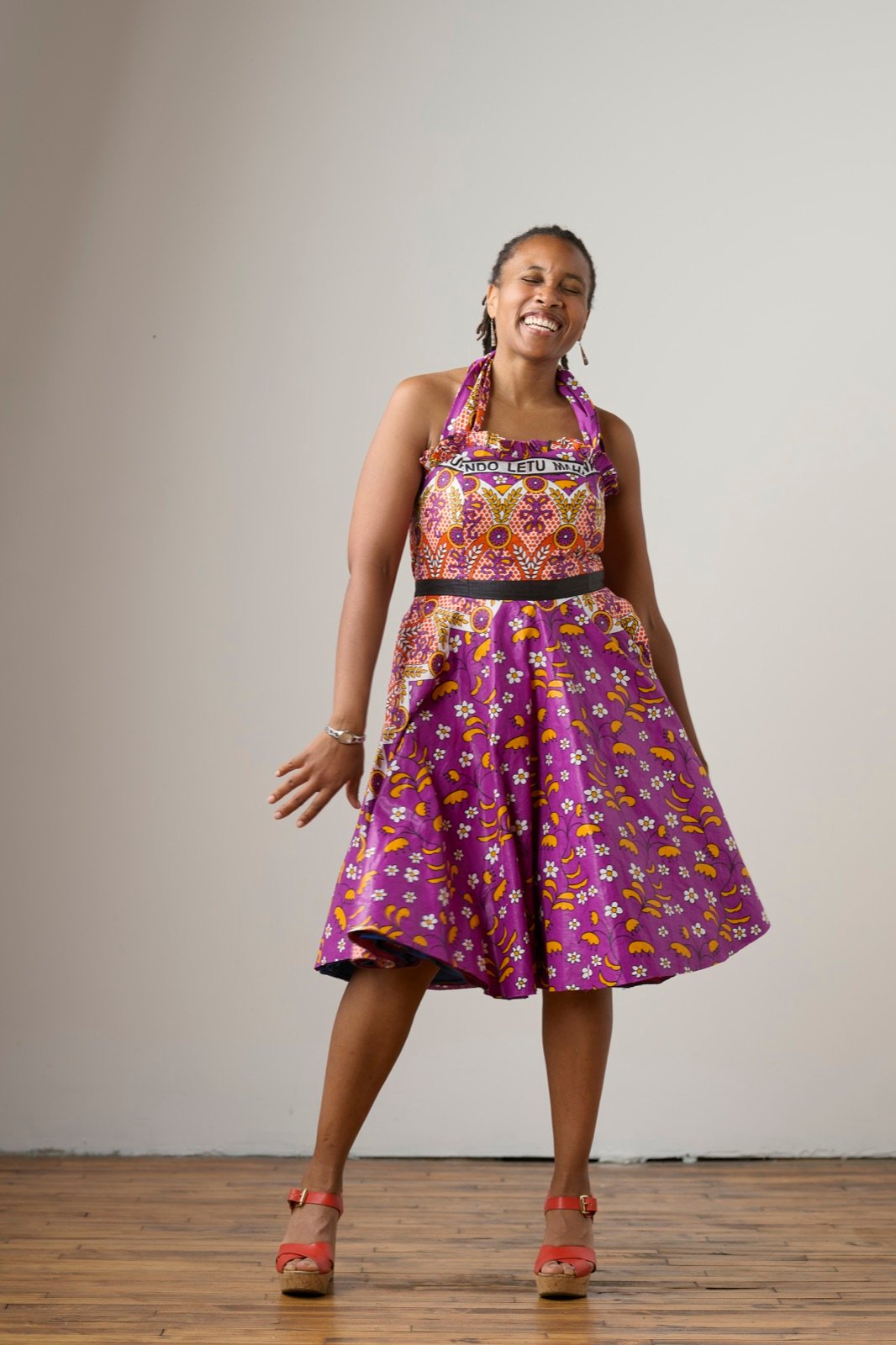 Rachel dancing and laughing in a colorful purple dress